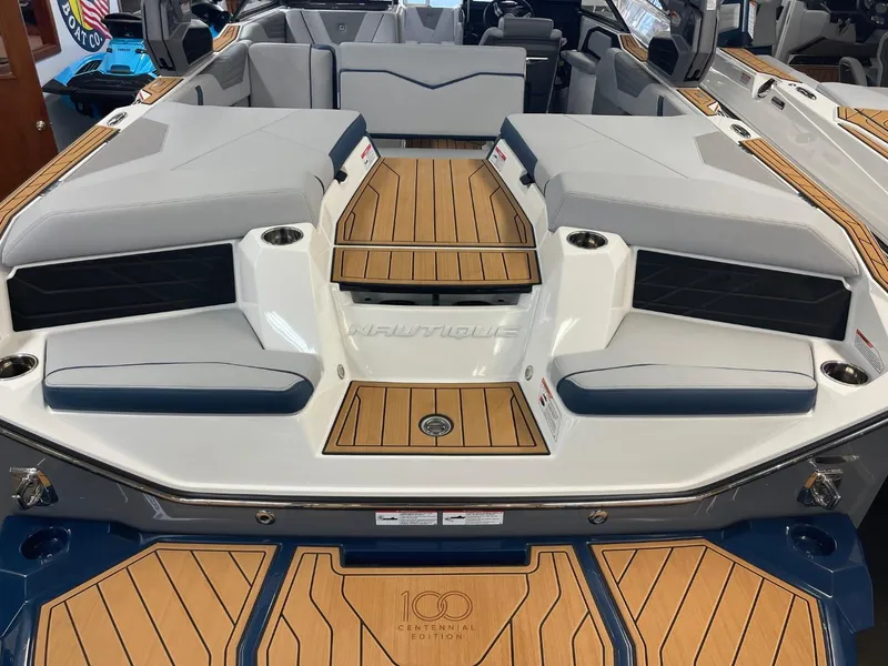 Slide: The Image of 2025 Nautique Super Air Nautique S21 boat interior with teak flooring and cushioned seating. - 27
