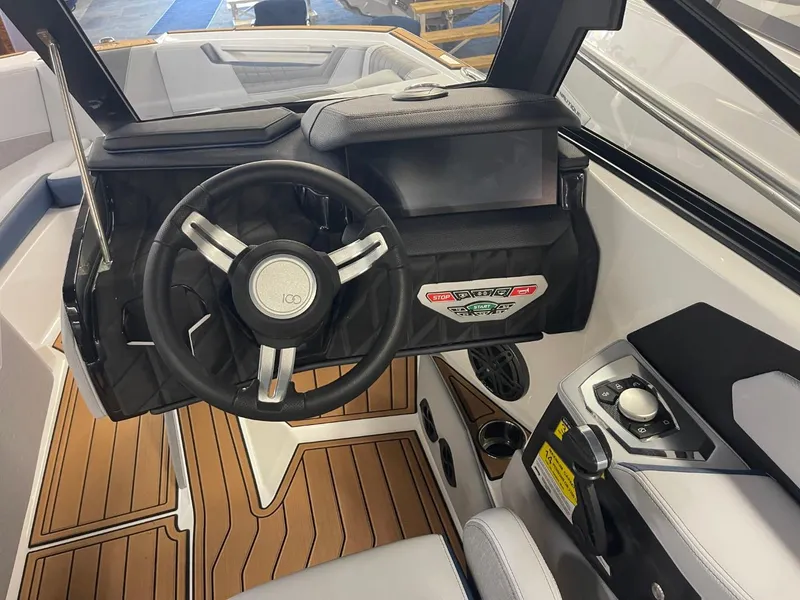 Slide: The Image of 2025 Nautique Super Air Nautique S21 cockpit with modern steering wheel and dashboard controls. - 33