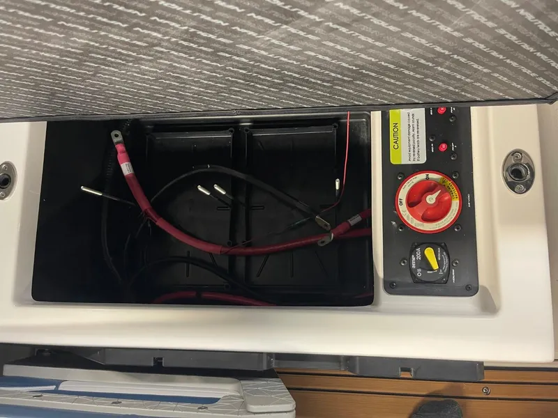 Slide: The Image of 2025 Nautique Super Air Nautique S21 battery compartment with cables and control panel. - 37