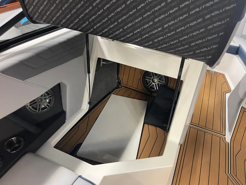 Slide: The Image of 2025 Nautique Super Air Nautique S21 interior with storage compartment and speakers. - 38