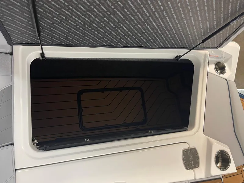 Slide: The Image of 2025 Nautique Super Air Nautique S21 storage compartment with open lid and sleek design. - 40