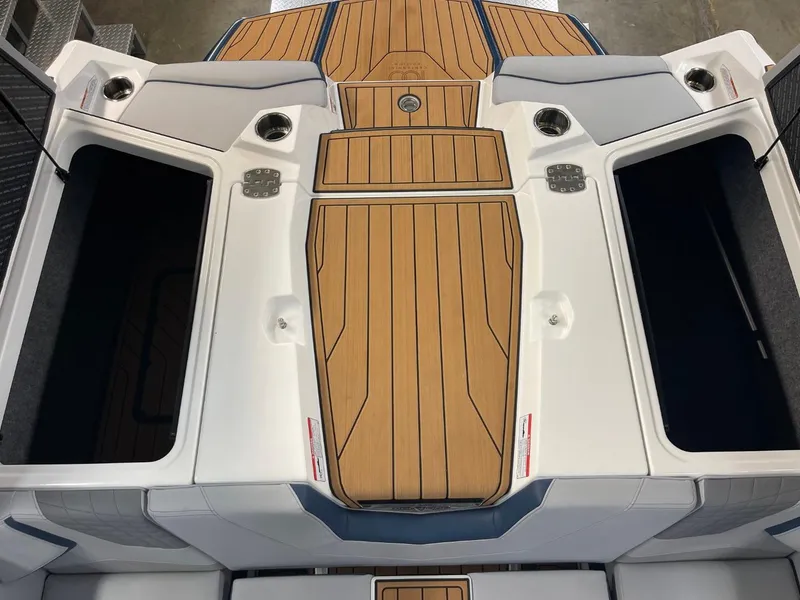 Slide: The Image of 2025 Nautique Super Air Nautique S21 boat deck with teak flooring and storage compartments. - 41