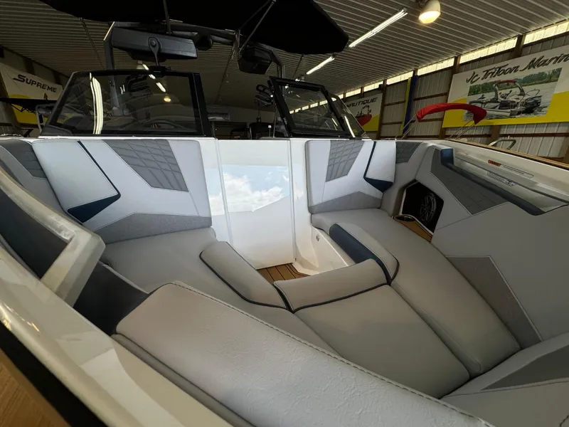 Slide: The Image of 2025 Nautique Super Air Nautique S21 interior with sleek, modern seating in a showroom. - 7