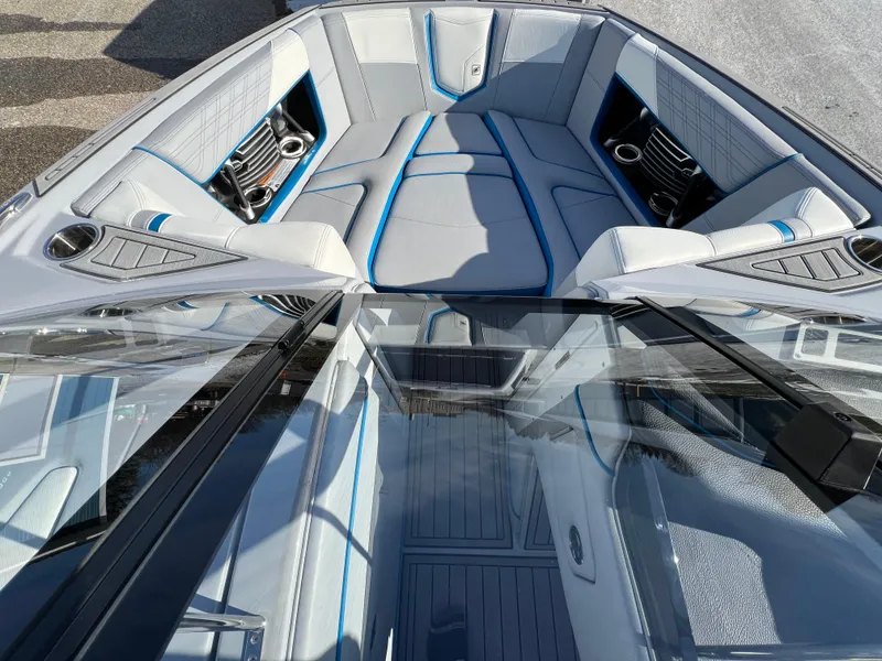 Slide: The Image of 2020 Nautique G21 boat interior with gray and blue seating, cup holders, and sleek design. - 25