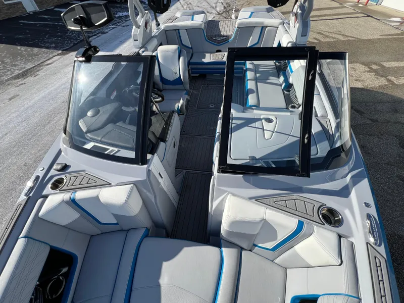 Slide: The Image of 2020 Nautique G21 boat interior with gray and blue seating, open windshield, and modern design. - 29