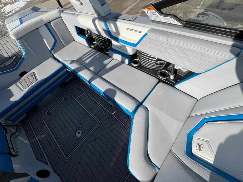 Slide: The Image of 2020 Nautique G21 boat interior with gray and blue seating, cup holders, and sleek design. - 32