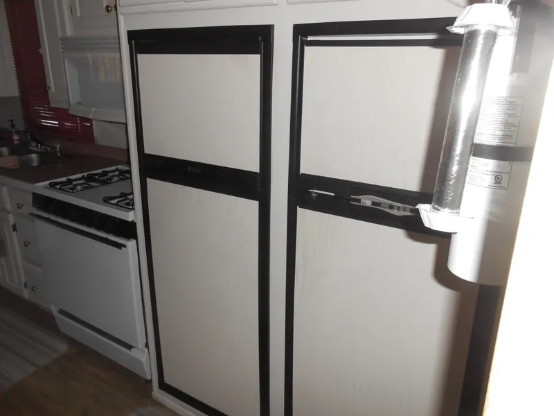 Slide: The Image of 1998 Lakeview 5516 kitchen with stove, refrigerator, and fire extinguisher. - 1