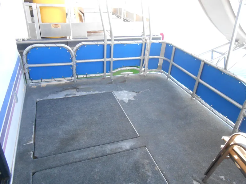 Slide: The Image of Spacious deck area on 1998 Lakeview 5516 houseboat with blue railing and carpeted floor. - 21