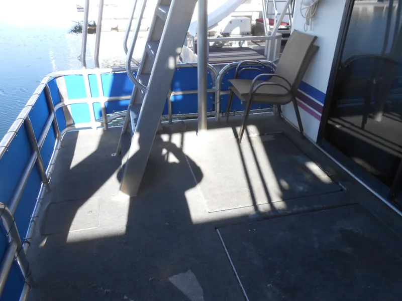 Slide: The Image of 1998 Lakeview 5516 boat deck with chair and railing, overlooking water. - 22