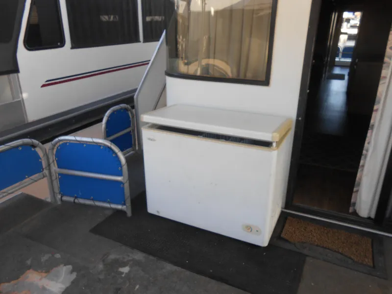 Slide: The Image of 1998 Lakeview 5516 houseboat with a white chest freezer on deck. - 23