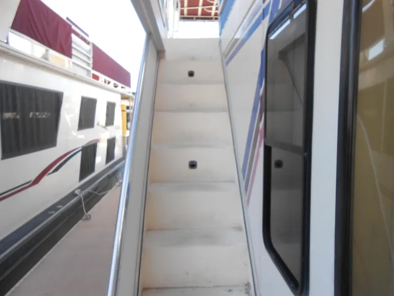 Slide: The Image of Staircase on a 1998 Lakeview 5516 houseboat, docked beside another boat. - 25