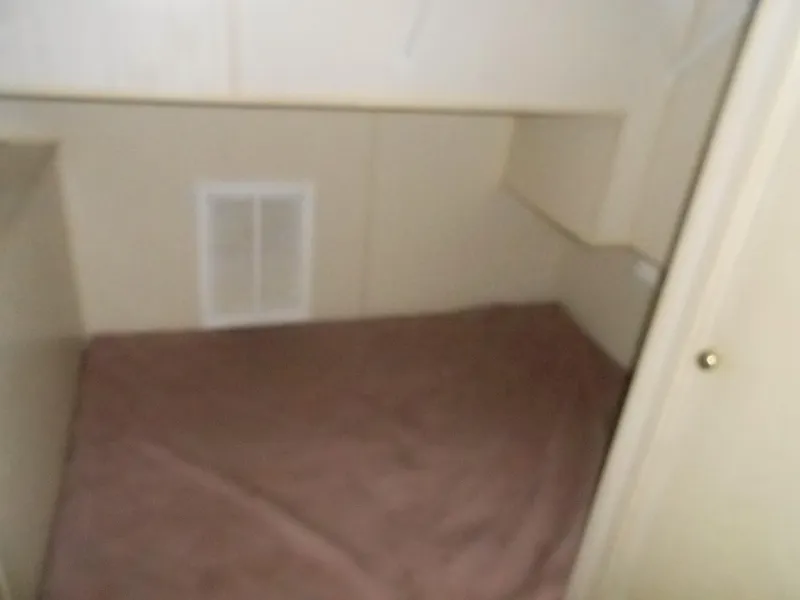 Slide: The Image of Small sleeping area in a 1998 Lakeview 5516 model, featuring a simple bed setup. - 9