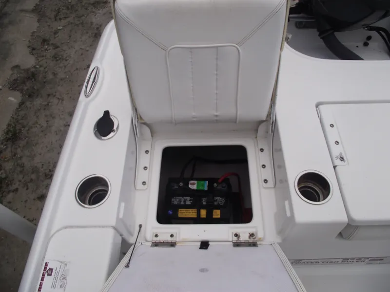 Slide: The Image of 2019 Sea Hunt BX 22 BR boat battery compartment with white seating and cup holders. - 30