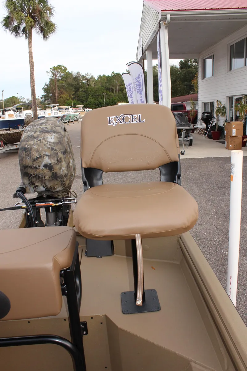 Slide: The Image of 2025 Excel 1860 F4 Shallow Water boat seat, tan color, outdoor dealership setting. - 10