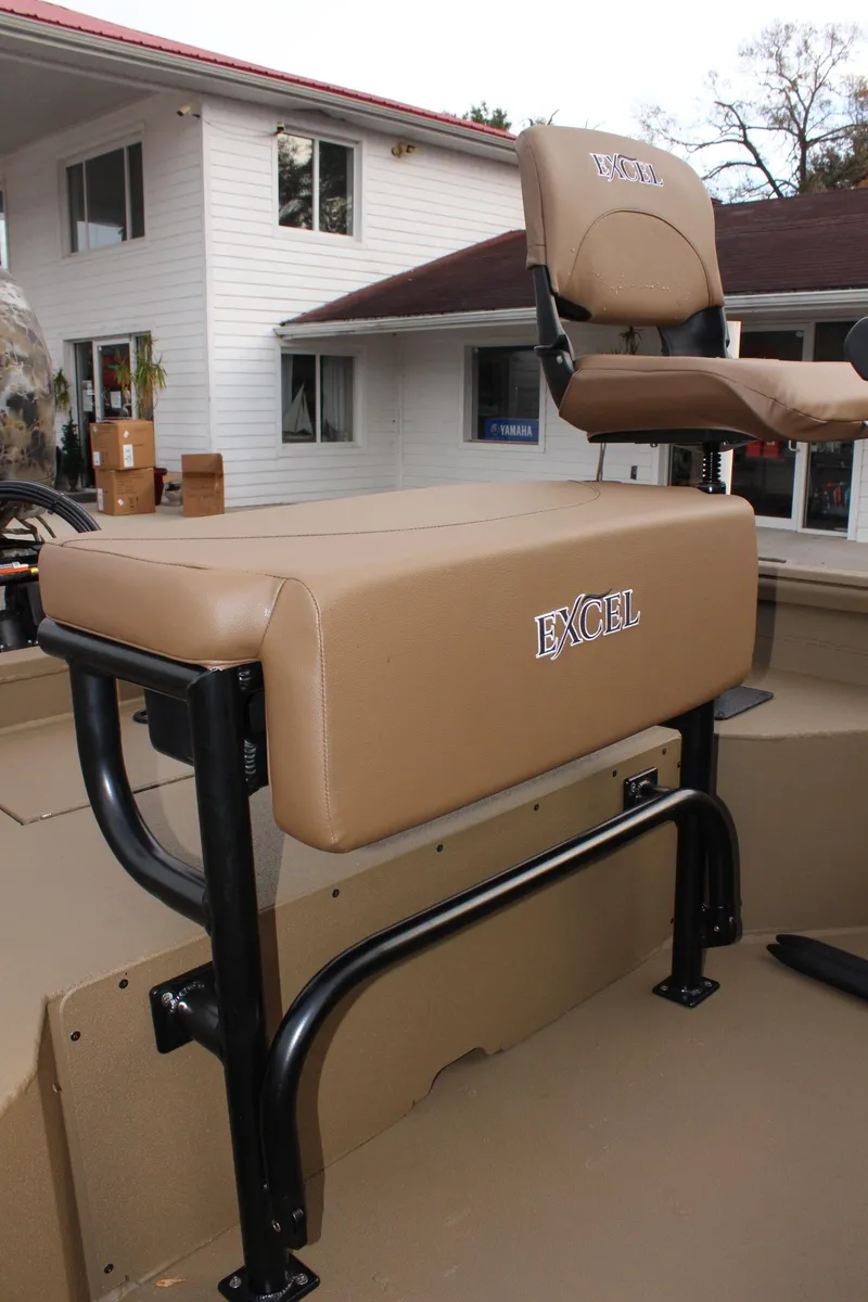 Slide: The Image of 2025 Excel 1860 F4 Shallow Water boat seat, tan upholstery, outdoor setting. - 11