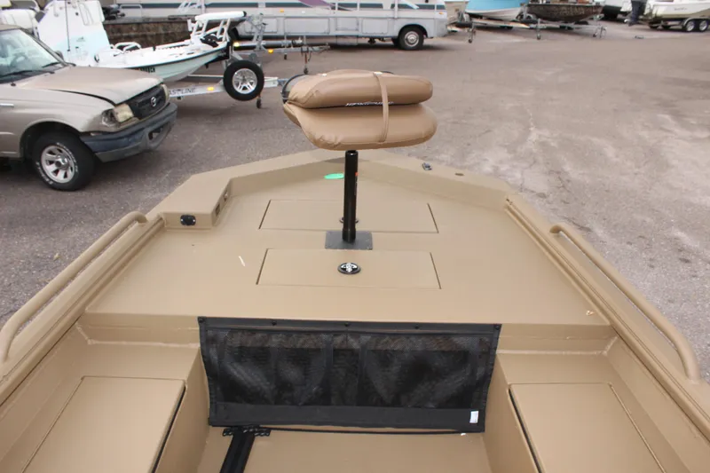 Slide: The Image of 2025 Excel 1860 F4 Shallow Water boat with tan seating and storage compartments. - 17