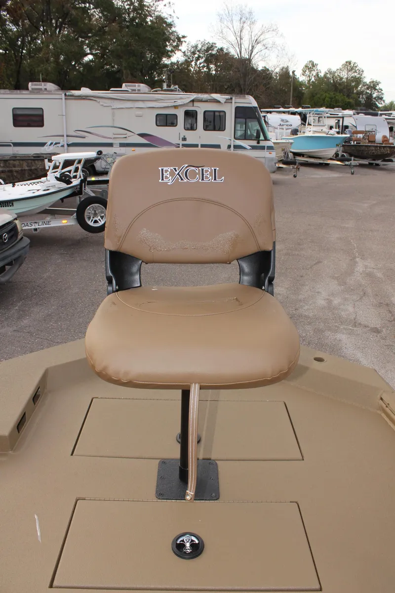 Slide: The Image of 2025 Excel 1860 F4 Shallow Water boat seat, parked in a lot with RVs and boats. - 20