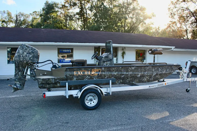 Slide: The Image of 2025 Excel 1860 F4 Shallow Water boat on trailer, camo design, parked outdoors. - 5