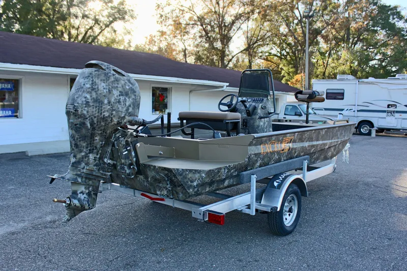 Slide: The Image of 2025 Excel 1860 F4 Shallow Water boat on trailer, camo design, parked outdoors. - 6