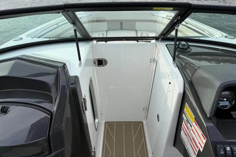 Slide: The Image of 2025 Monterey M6 boat interior with open compartment and dashboard view. - 19