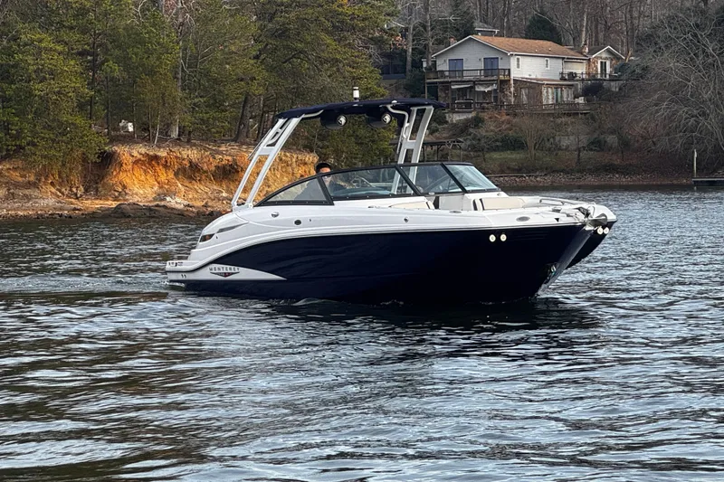 Slide: The Image of 2025 Monterey M6 boat cruising on a scenic lake near wooded shoreline. - 3