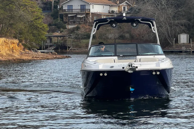 Slide: The Image of 2025 Monterey M6 boat cruising on a serene lake near waterfront homes. - 4