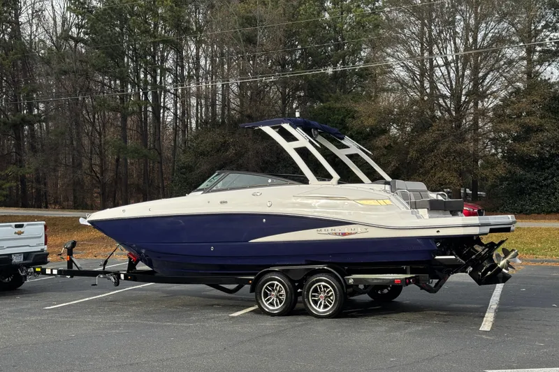 Slide: The Image of 2025 Monterey M6 boat on trailer in parking lot, surrounded by trees. - 7