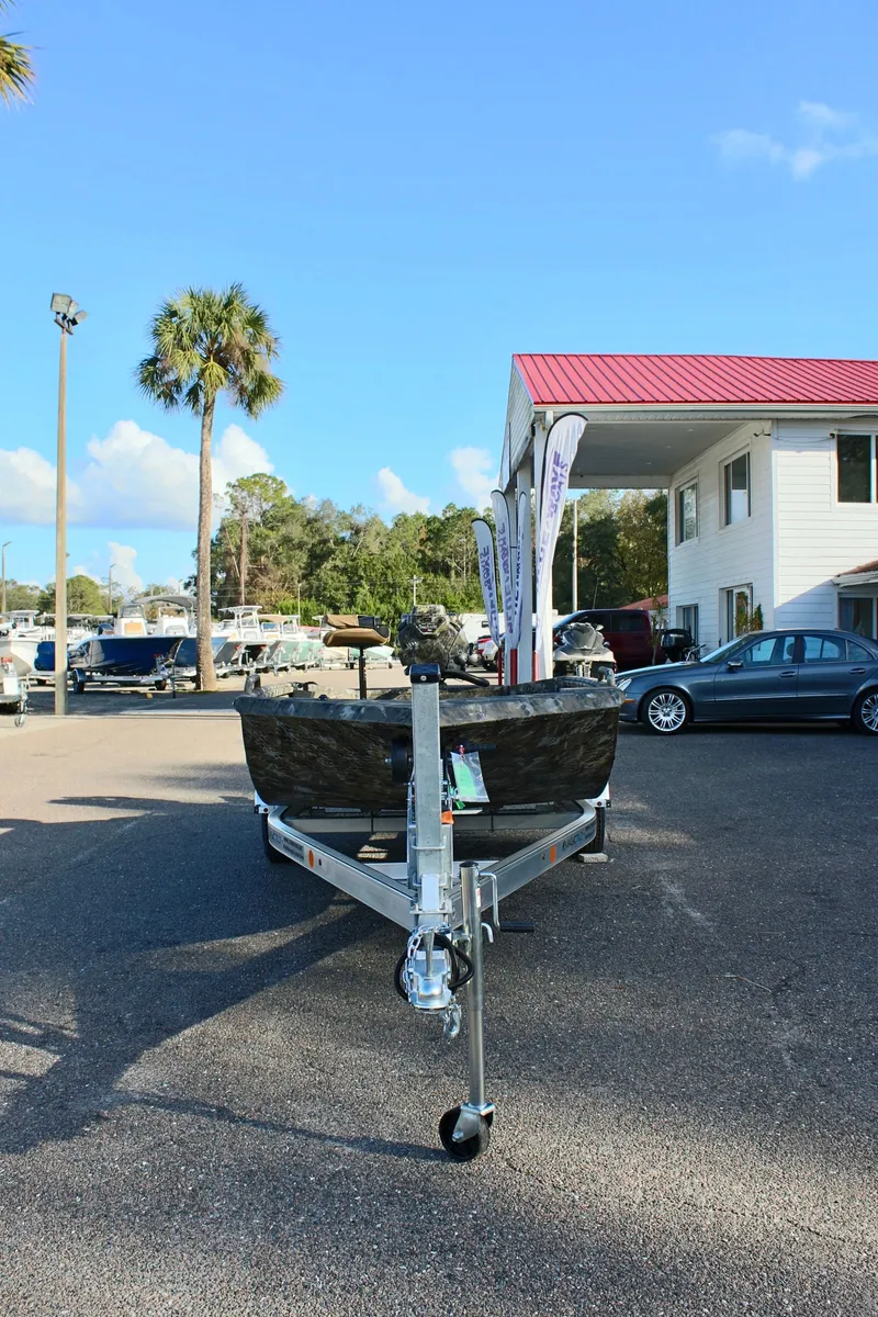 Slide: The Image of 2025 Excel 1860 F4 Shallow Water boat on trailer at dealership, sunny day. - 3