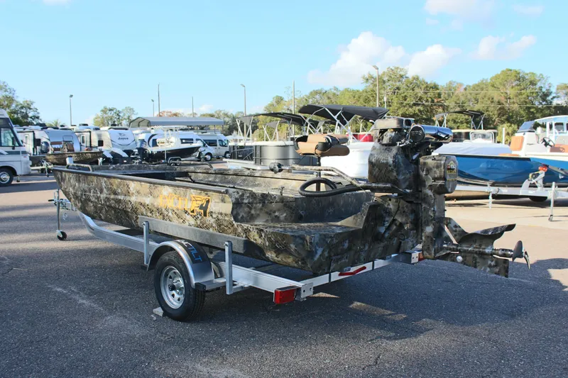 Slide: The Image of 2025 Excel 1860 F4 Shallow Water boat on trailer, camo design, parked outdoors. - 7