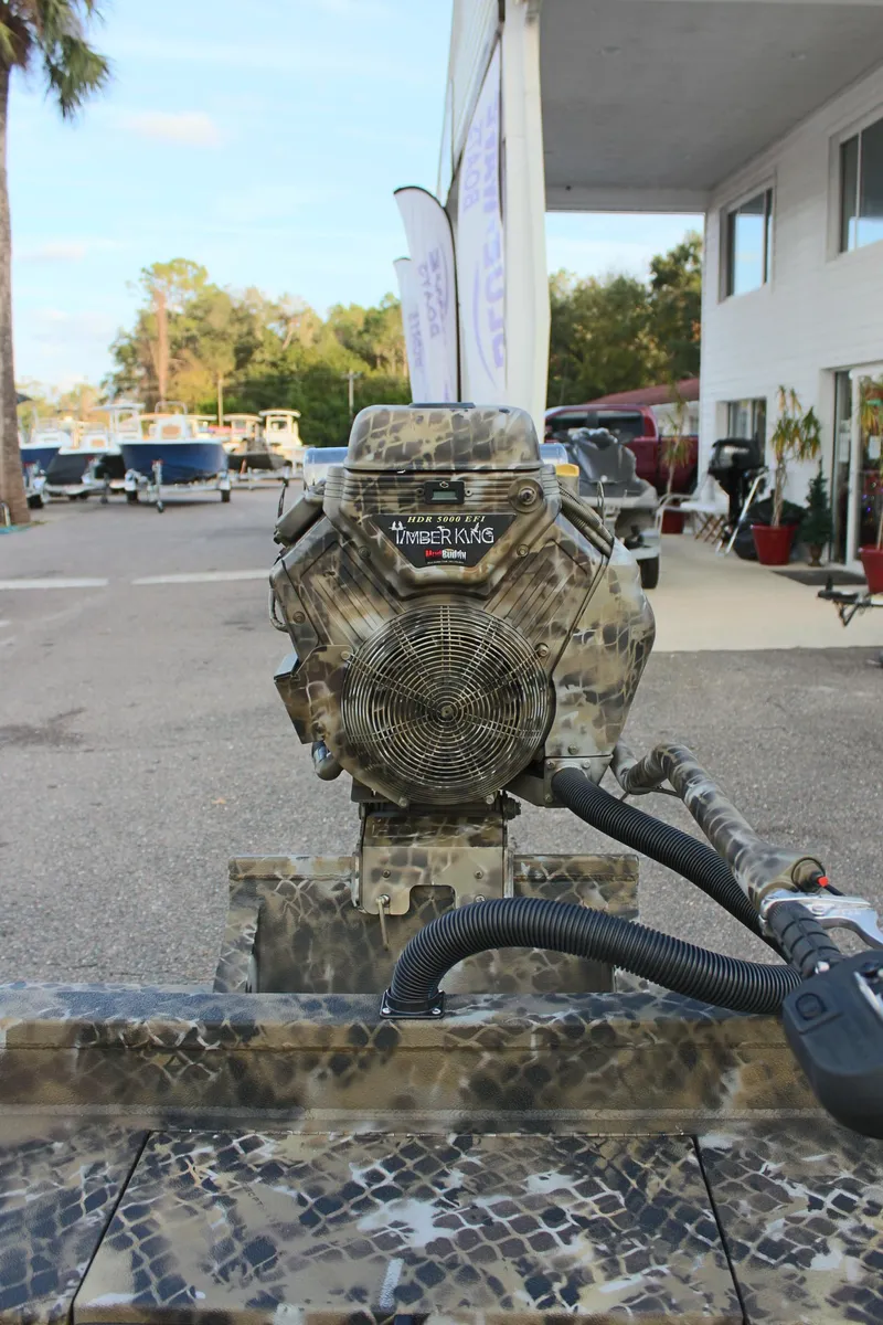 Slide: The Image of 2025 Excel 1860 F4 Shallow Water boat with camouflage design in outdoor setting. - 9