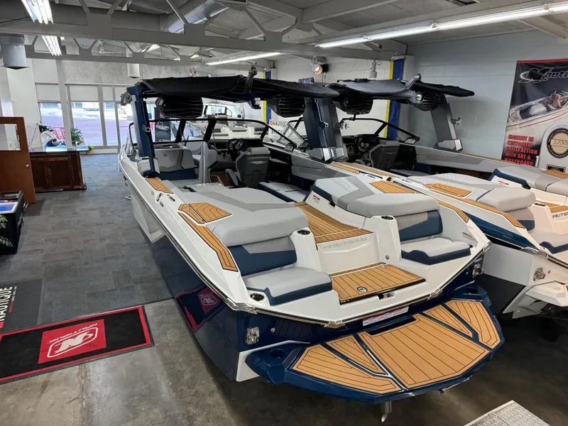 Slide: The Image of 2024 Nautique Super Air Nautique G23 boat in showroom, featuring sleek design and modern amenities. - 11