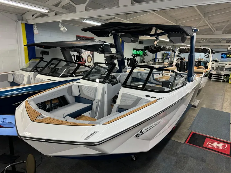 Slide: The Image of 2024 Nautique Super Air Nautique G23 boat in showroom, featuring sleek design and modern amenities. - 13