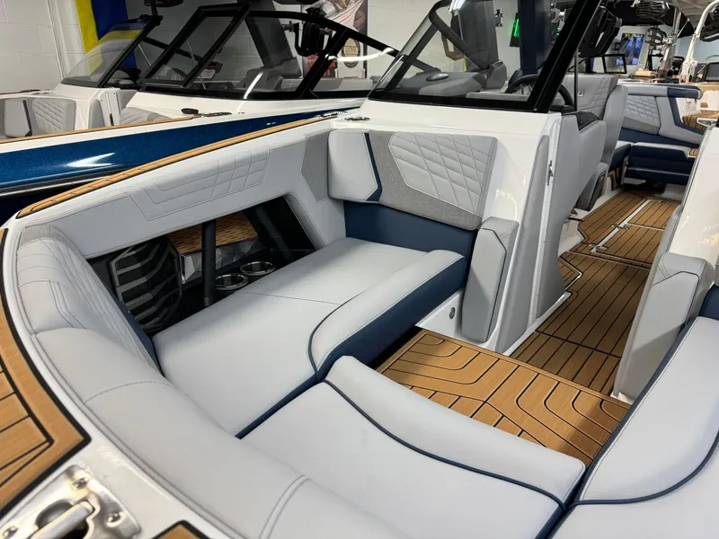 Slide: The Image of 2024 Nautique Super Air Nautique G23 interior with luxurious seating and teak flooring. - 15