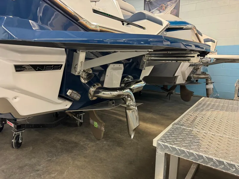 Slide: The Image of 2024 Nautique Super Air Nautique G23 boat rear view in a showroom. - 24