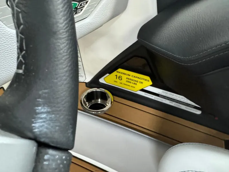 Slide: The Image of 2024 Nautique Super Air Nautique G23 interior, steering wheel, cup holder, capacity label. - 32