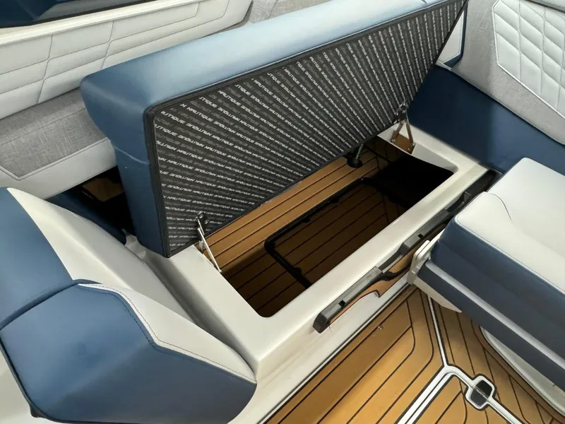 Slide: The Image of 2024 Nautique Super Air Nautique G23 interior storage compartment with blue and white seating. - 41