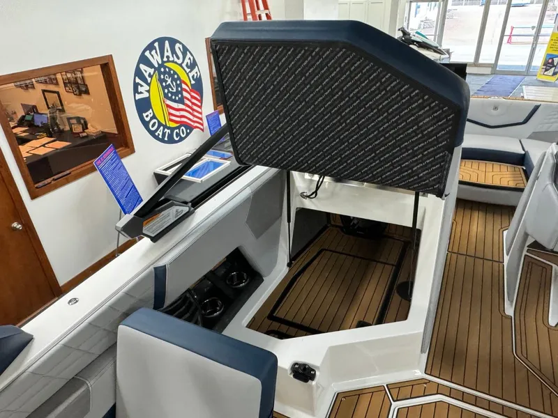 Slide: The Image of 2024 Nautique Super Air Nautique G23 interior with open storage compartment and seating. - 42