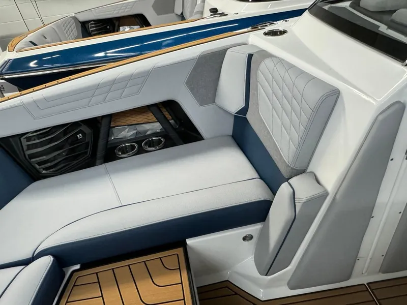 Slide: The Image of 2024 Nautique Super Air Nautique G23 interior with blue and white seating, luxury design. - 47