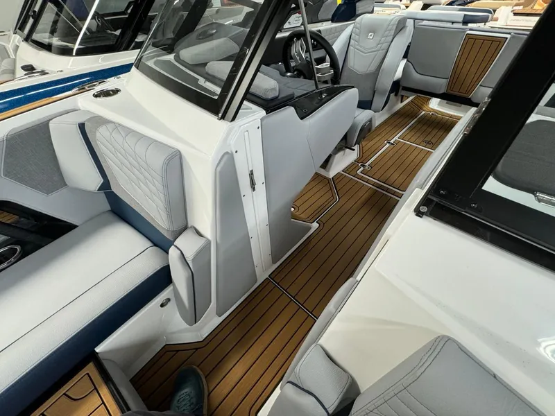 Slide: The Image of 2024 Nautique Super Air Nautique G23 interior with luxurious seating and teak flooring. - 49