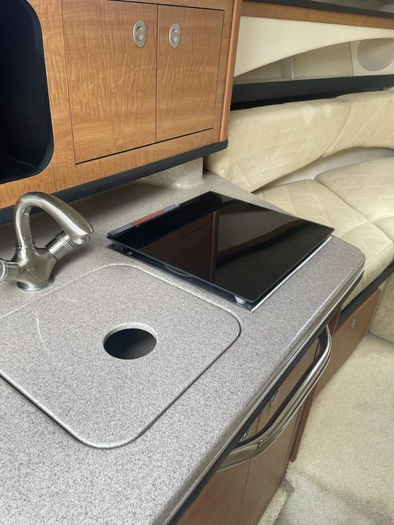 Slide: The Image of 2006 Sea Ray 270 Amberjack cabin interior with kitchenette and seating area. - 11