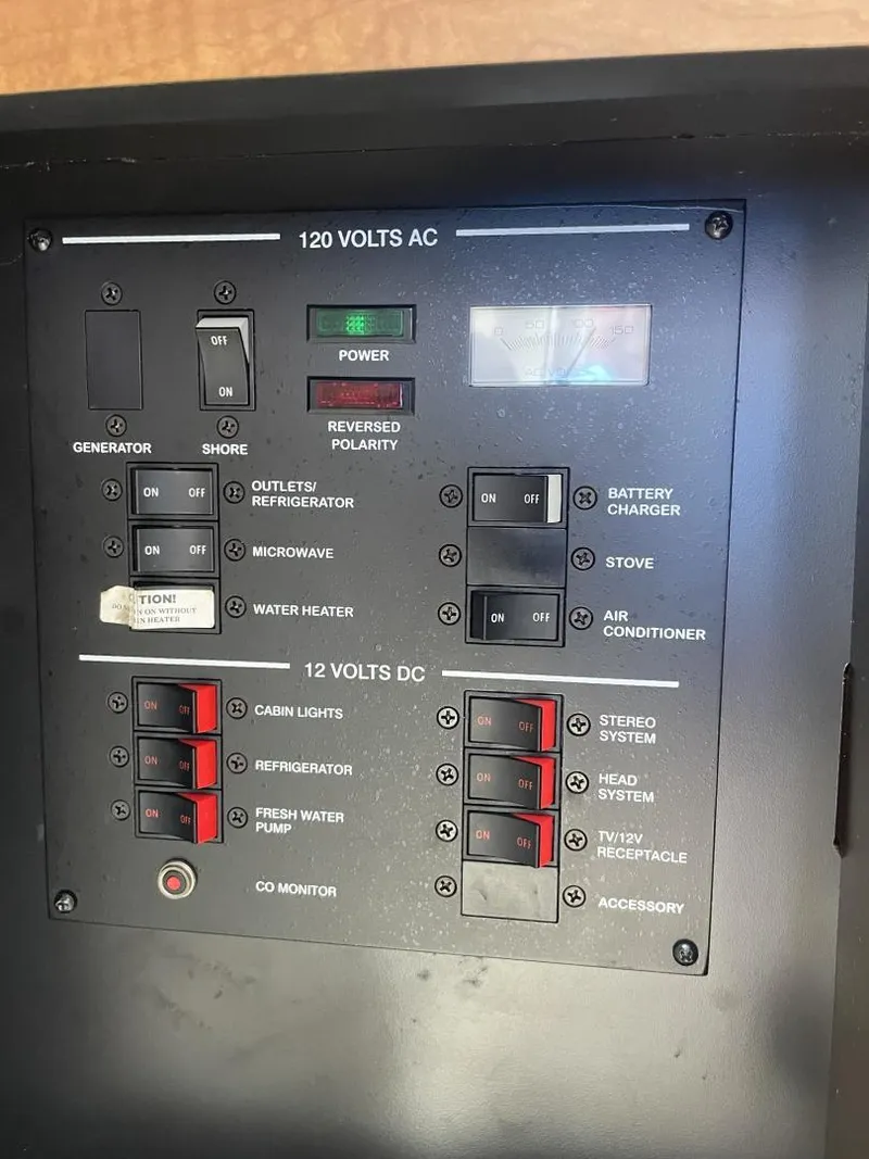 Slide: The Image of Control panel of a 2006 Sea Ray 270 Amberjack boat, showing AC/DC switches and indicators. - 14