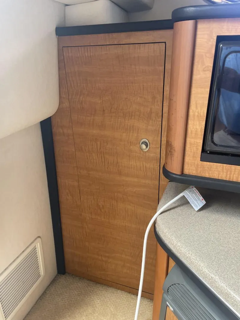 Slide: The Image of Interior of 2006 Sea Ray 270 Amberjack boat with wooden cabinet and countertop. - 16