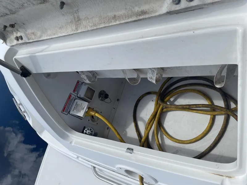Slide: The Image of Storage compartment of 2006 Sea Ray 270 Amberjack with coiled yellow hose. - 19