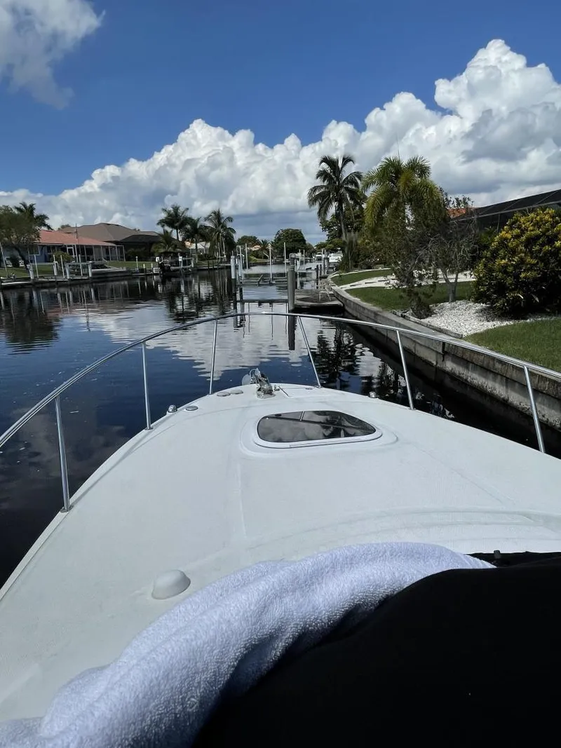 Slide: The Image of 2006 Sea Ray 270 Amberjack cruising on a scenic canal with palm trees and blue sky. - 29