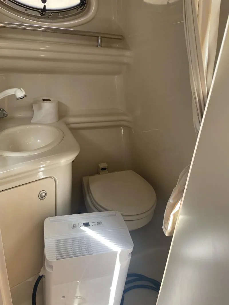 Slide: The Image of 2006 Sea Ray 270 Amberjack bathroom with sink, toilet, and dehumidifier. - 7