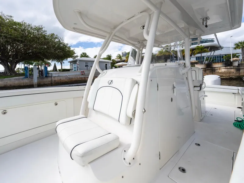 Slide: The Image of 2017 Jupiter 34 HFS boat interior with seating and console, docked near trees and buildings. - 15