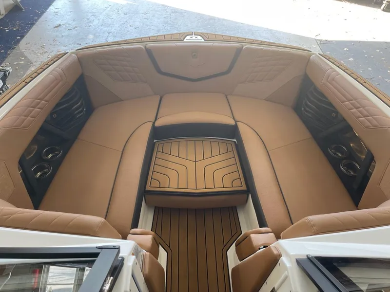 Slide: The Image of 2024 Nautique Super Air Nautique G23 interior with tan seating and wood accents. - 10