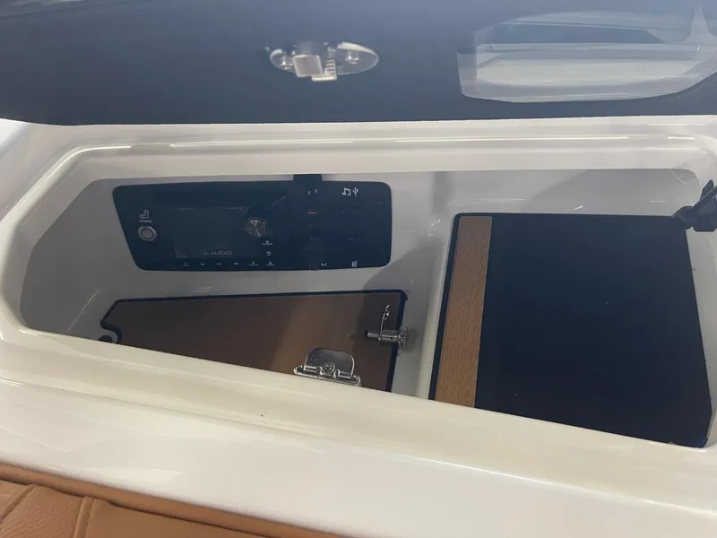 Slide: The Image of 2024 Nautique Super Air Nautique G23 storage compartment with control panel and latch. - 17