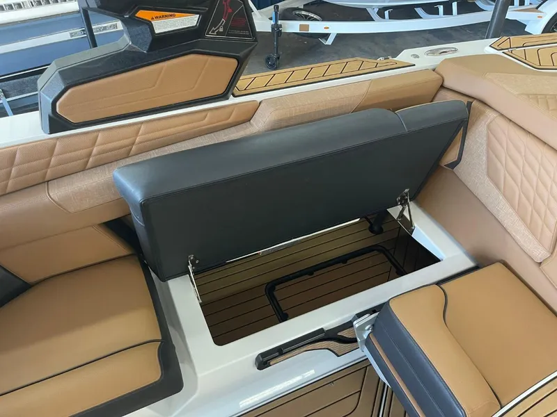 Slide: The Image of 2024 Nautique Super Air Nautique G23 interior seating with storage compartment open. - 19