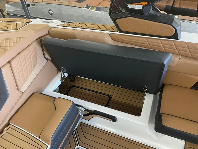 Slide: The Image of 2024 Nautique Super Air Nautique G23 interior seating with storage compartment open. - 20